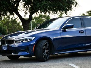 Blue sedan parked outdoors on a summer day in Arlington, Texas, showcasing luxury design and style.
